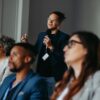 Businessman,Asking,A,Question,During,A,Diverse,Conference,Workshop,Presentation.