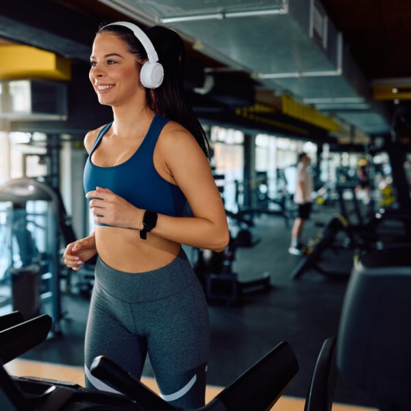 Happy,Athletic,Woman,Exercising,On,Treadmill,During,Sports,Training,In